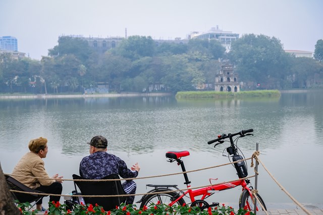 Hai người đàn ông sau khi đạp xe dạo quanh bờ Hồ đã ngồi hàn huyên vào ngày đầu năm mới.